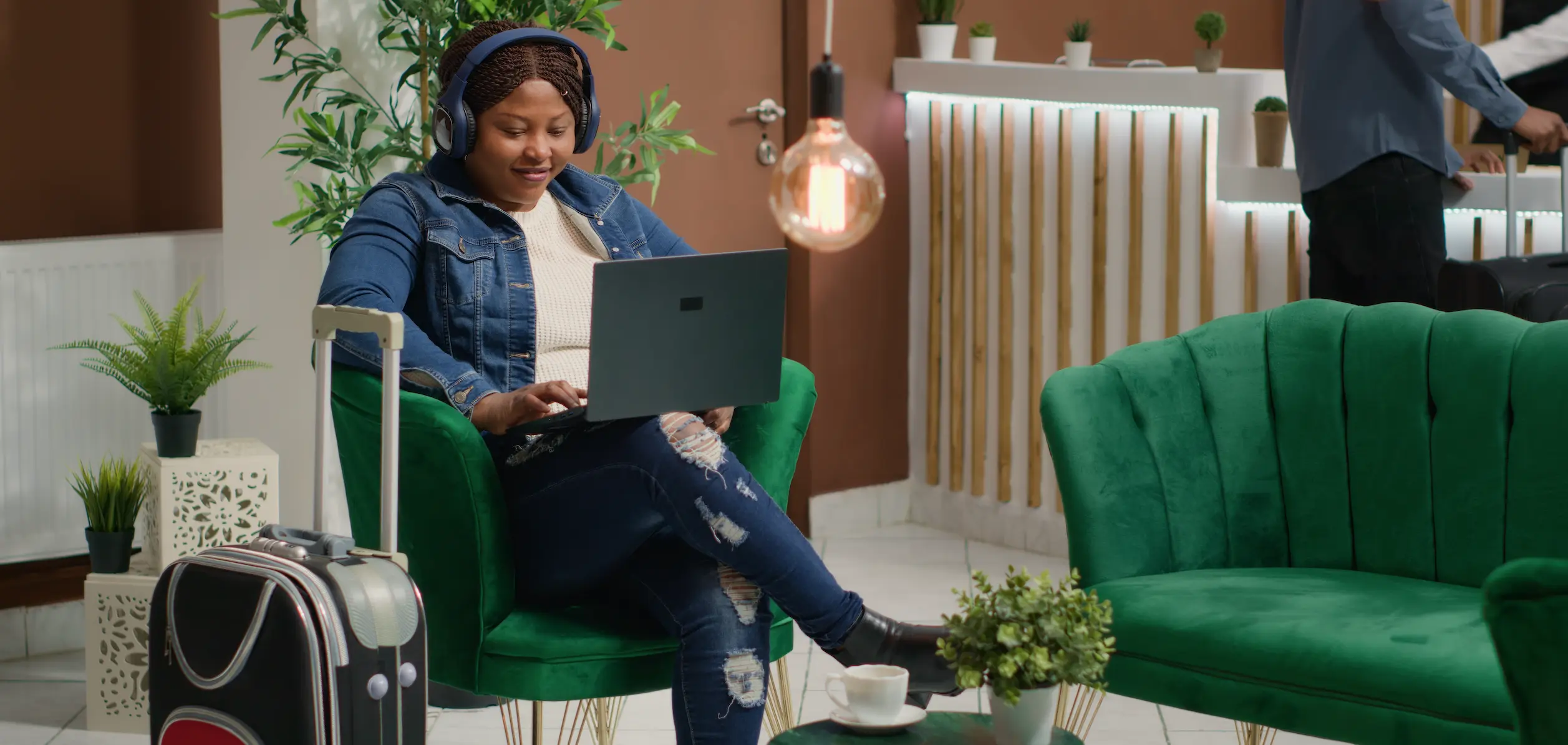 Traveller in airport lounge having coffee using laptop